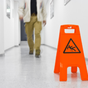 person walking on floor with slippery sign