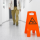 person walking on floor with slippery sign